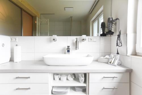 a white bathroom with a sink and a mirror at Ferienwohnung Spreeblick in Alter Graben