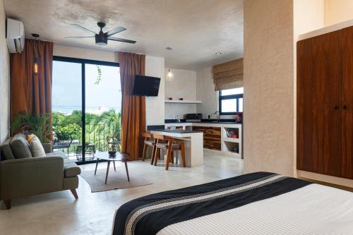 a bedroom with a bed and a kitchen with a table at UJO Condo Boutique in Tulum