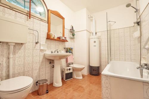 法拉-迪索利戈的住宿－Rustico Costa D'oro，浴室配有卫生间、盥洗盆和浴缸。