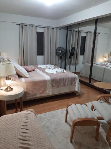 een slaapkamer met een groot bed en een grote spiegel bij Casa Schmidt Centro Pedra Azul in Pedra Azul