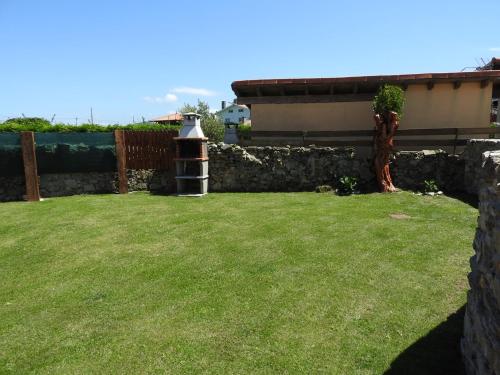a garden with a stone wall and a bird feeder at La Casina in Oviñana