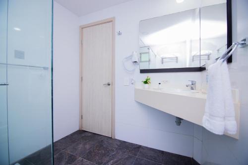 a white bathroom with a sink and a mirror at Varanasi Hotel Boutique Aeropuerto in Cartagena de Indias
