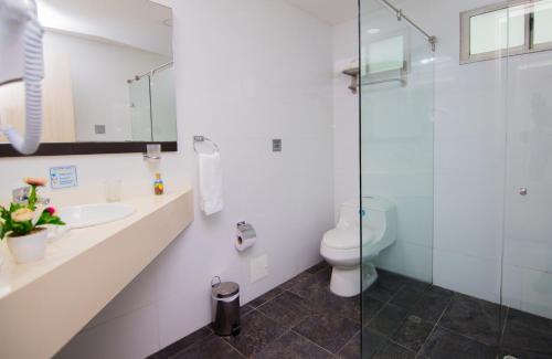 a bathroom with a toilet and a glass shower at Varanasi Hotel Boutique Aeropuerto in Cartagena de Indias