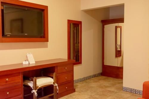 a room with a desk with a television and a chair at Santa Helena Plaza in Oaxaca City