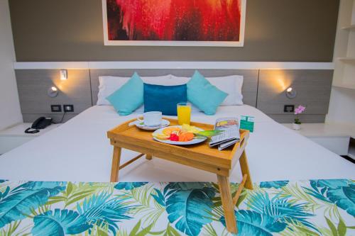 a table with a plate of fruit on a bed at Varanasi Hotel Boutique Aeropuerto in Cartagena de Indias