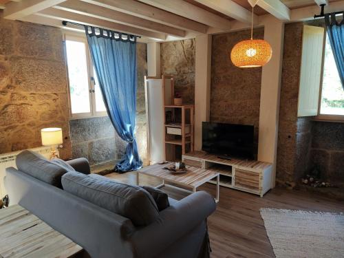 a living room with a couch and a tv at OLardoMar in Carnota