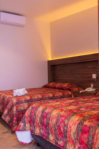 a hotel room with two beds and a phone at Santa Helena Plaza in Oaxaca City