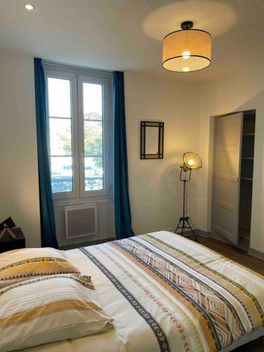 a bedroom with a large bed and a window at T2 face gare SNCF Appart Hotel le Cygne 1 in Bourges