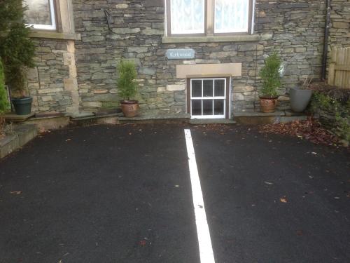 a parking lot in front of a stone building at Kirkwood Guest House in Windermere