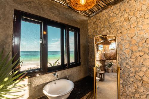 a bathroom with a toilet and a view of the beach at Playa Esperanza Tulum in Tulum