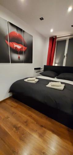 a bedroom with two beds and a painting on the wall at HAPPY - VIP Apartment - ApartamentyHappy pl in Tarnów