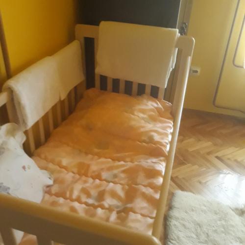 a wooden chair with a blanket on it at Apartman "Dom Stankovića" in Pirot
