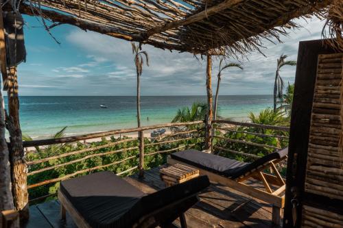 a room with a view of the beach and the ocean at Playa Esperanza Tulum in Tulum