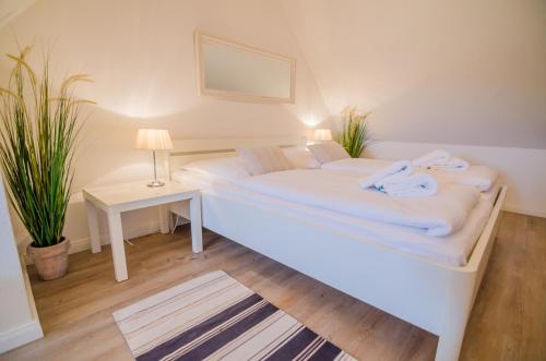 a bedroom with two beds and a table with a lamp at Westbrise App 7 in Wenningstedt