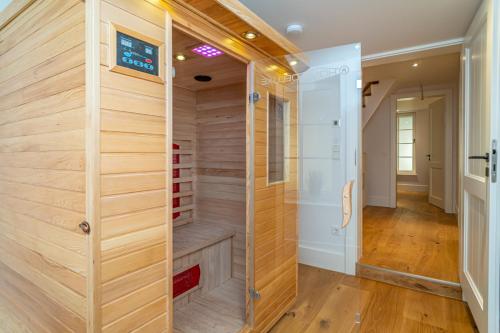 a walk in shower in a room with wooden walls at Am Lee in Tinnum