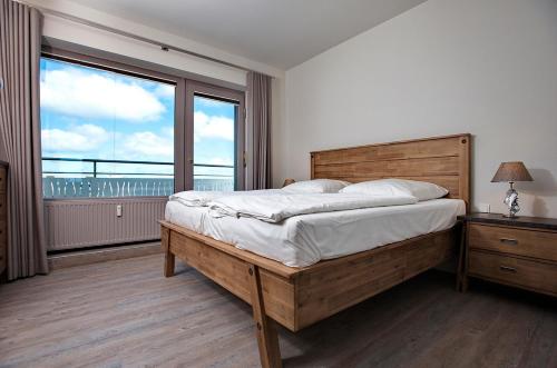 ein Schlafzimmer mit einem großen Bett und einem großen Fenster in der Unterkunft App WolkenLoft in Westerland