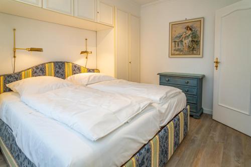 una camera con un grande letto e un comò blu di App Störtebeker App 16 a Westerland