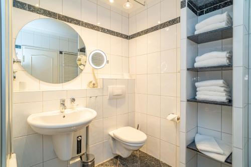 un bagno con lavandino, WC e specchio di App Störtebeker App 16 a Westerland