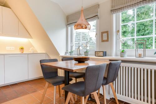 a kitchen and dining room with a wooden table and chairs at Sönshörn Suite in Munkmarsch
