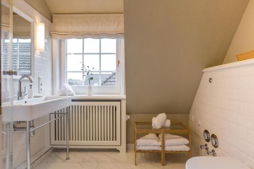 a bathroom with a sink and a window at Sönshörn Suite in Munkmarsch