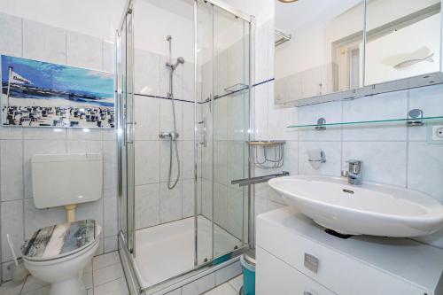 een badkamer met douche, wastafel en toilet bij Constantin in Tinnum