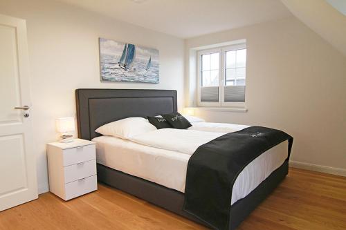 a bedroom with a large bed and a window at Gode Stuv in Westerland