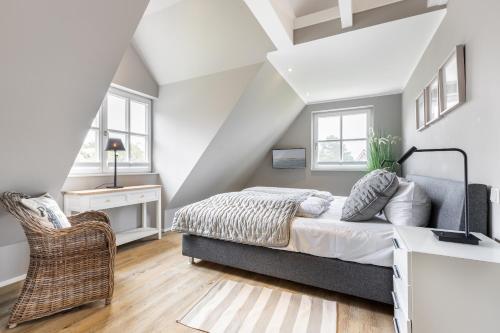 a bedroom with a bed and a chair at Anker Hus in Westerland