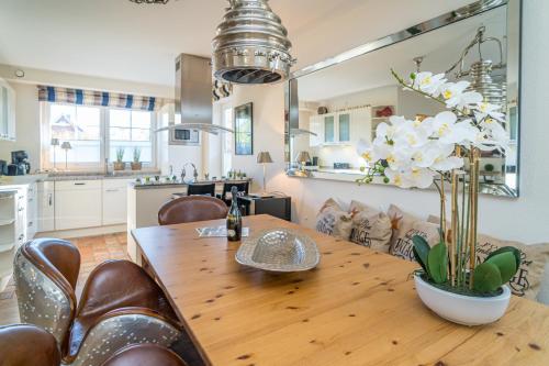 a kitchen and dining room with a wooden table and chairs at Maarwiet Hüs in Wenningstedt