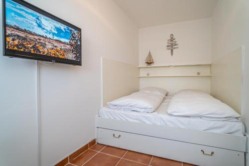 Schlafzimmer mit einem Bett und einem TV an der Wand in der Unterkunft Seestern in Westerland