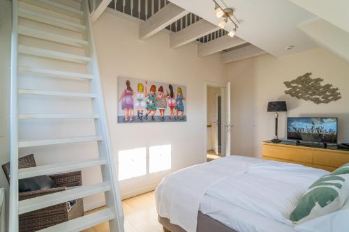 a bedroom with a ladder and a bed and a tv at Maarwiet Hüs in Wenningstedt