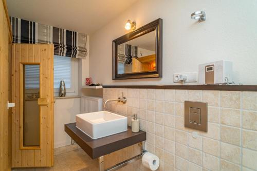 a bathroom with a sink and a mirror at Maarwiet Hüs in Wenningstedt
