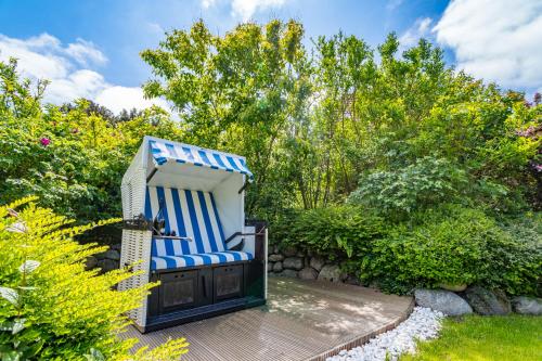 a blue and white chair sitting on a wooden deck at Maarwiet Hüs in Wenningstedt