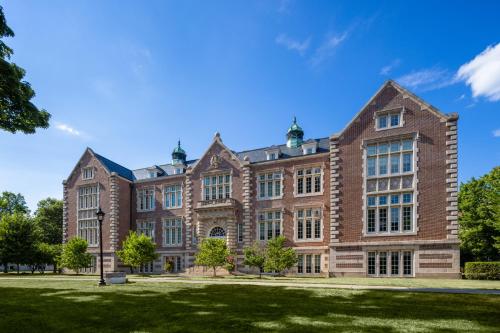 a large brick building with a green lawn at Holiday Inn Poughkeepsie by IHG in Poughkeepsie