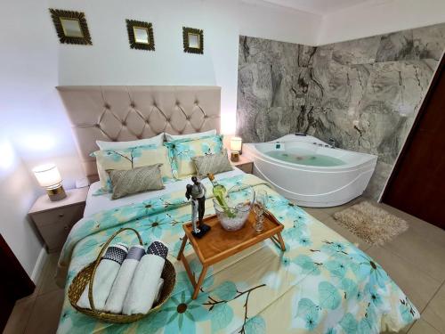 a bedroom with a bed with a bath tub and a sink at Ecusuites Jacuzzi Executive Dpto Riverfront l puerto santa ana in Guayaquil