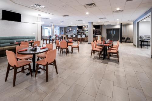 Holiday Inn Poughkeepsie, an IHG Hotel في باوكيبسي: غرفة طعام مع طاولات وكراسي في مطعم