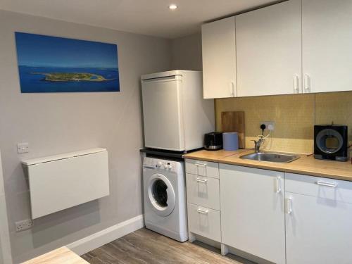 a kitchen with a washing machine and a sink at Estuary View Apartment in Kilrush