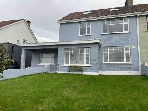 a blue house with a bench in the yard at Estuary View Apartment in Kilrush