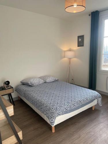 - une chambre avec un lit et une lampe dans l'établissement T2 4 pers face gare SNCF Appart Hotel le Cygne 3, à Bourges