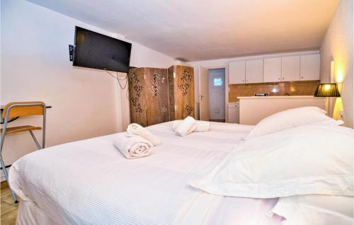 - 2 lits dans une chambre avec des draps blancs et des serviettes dans l'établissement Beautiful Apartment In Sainte-maxime With Wifi, à Sainte-Maxime