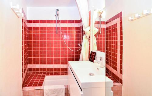 La salle de bains est pourvue d'une douche carrelée de rouge et d'un lavabo. dans l'établissement Beautiful Apartment In Sainte-maxime With Wifi, à Sainte-Maxime
