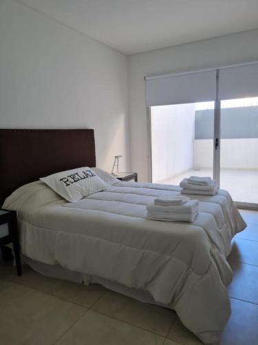 a bedroom with a large bed with towels on it at Marina in Puerto Madryn