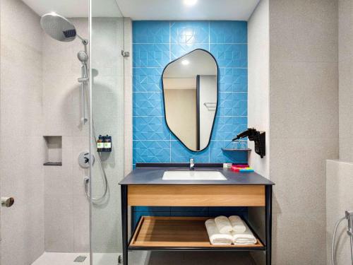 ein Bad mit einem Waschbecken und einem Spiegel in der Unterkunft ibis Styles Semarang Simpang Lima in Semarang