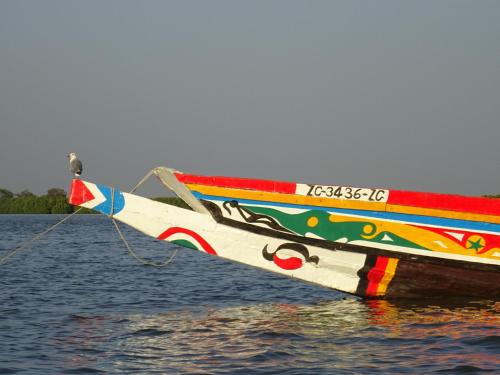 a colorful boat sitting on top of a body of water at Kansala Ta Toto in Kafountine