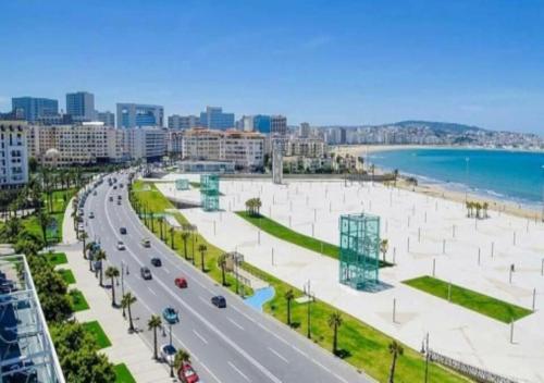 a street in a city with a road and a beach at Ap 2ch city centre parking en face Hilton a cote du plage in Tangier