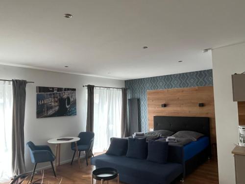 a bedroom with a blue bed and a table and chairs at Gasthaus am Henriettenhof in Grömitz