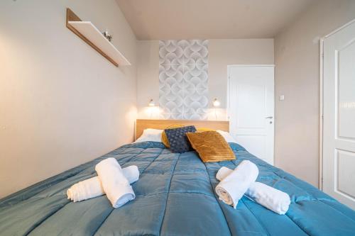 Pastelle Apartment with own parking place في بودابست: غرفة نوم بسرير ازرق عليها مناشف