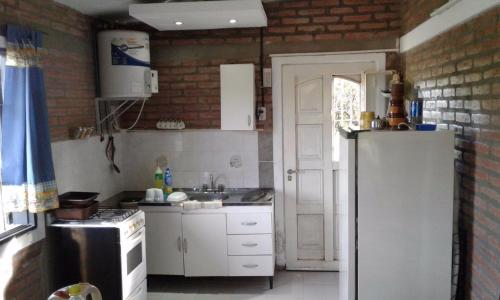 een keuken met witte kasten en een witte koelkast bij Postal Serrana in Villa Parque Siquiman