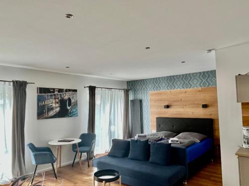 a living room with a blue couch and a table at Gasthaus am Henriettenhof in Grömitz