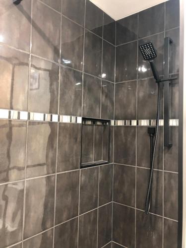 a bathroom with a shower with black tile at Rockridge Farm 