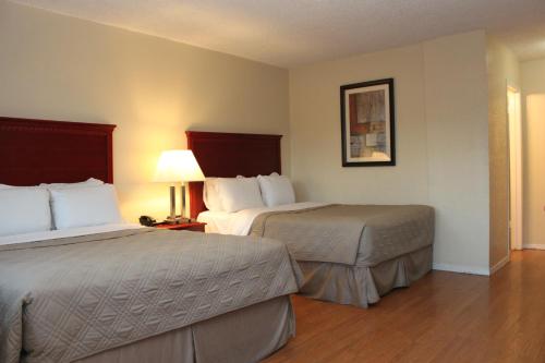 a hotel room with two beds and a lamp at Budget Inn in Lompoc